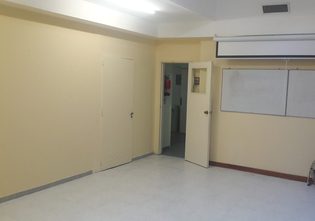 Sala despejada y amplia con pantalla y pizarras
